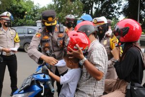 Kapolres Pandeglang Bagikan Helm dan Masker Kepada Pengendara